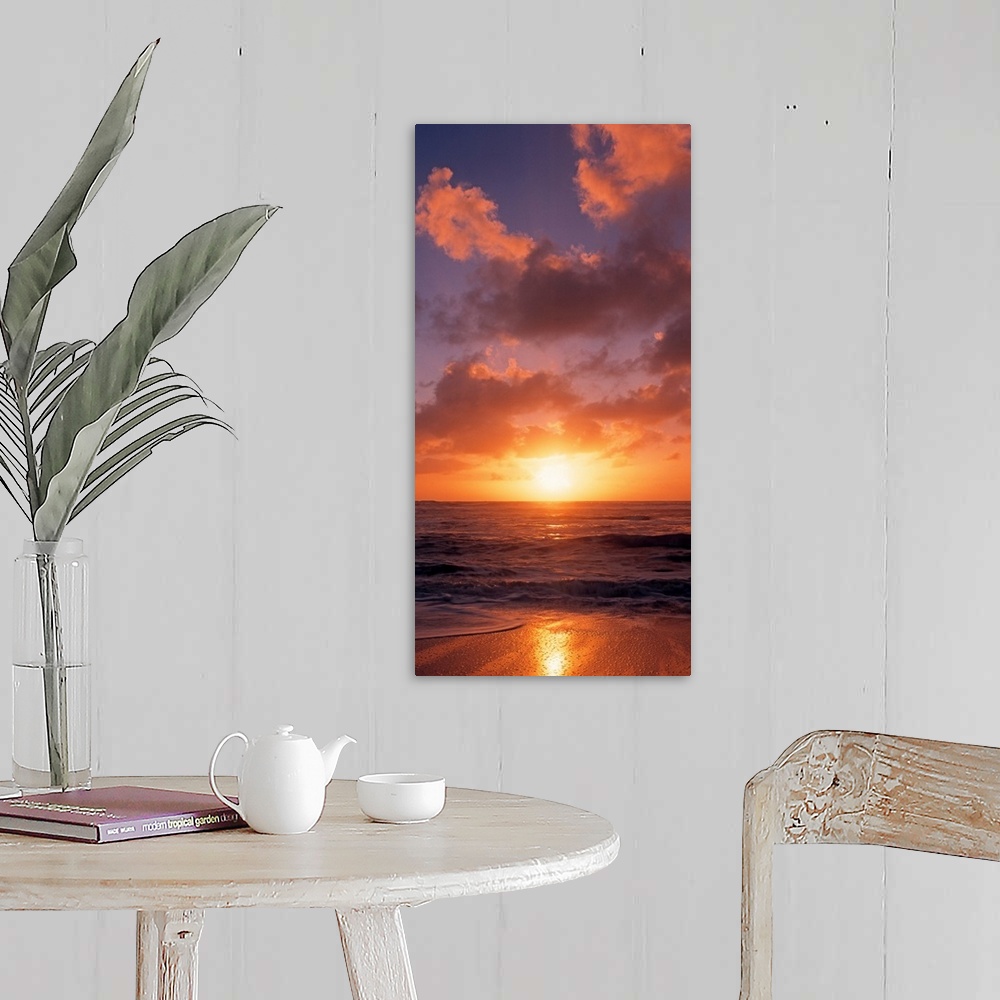 A farmhouse room featuring This vertical photograph shows the sun setting at the beach as waves wash against the shore.