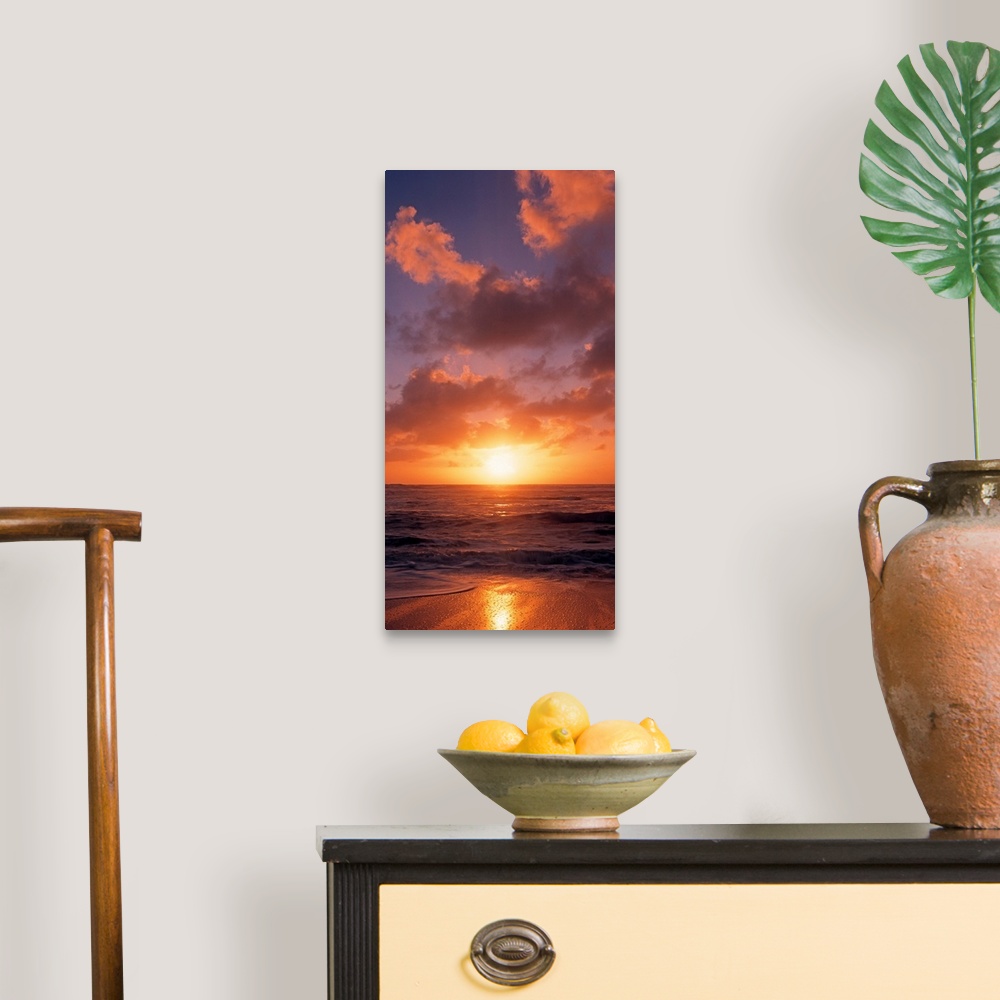 A traditional room featuring This vertical photograph shows the sun setting at the beach as waves wash against the shore.