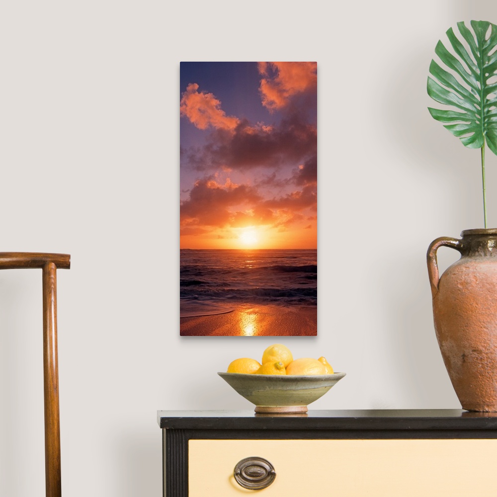 A traditional room featuring This vertical photograph shows the sun setting at the beach as waves wash against the shore.