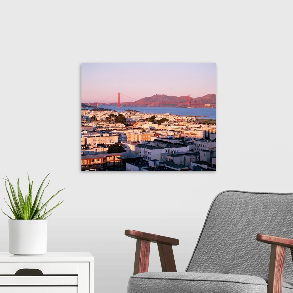 A modern room featuring This decorative wall art is a photograph of houses around the bay and the Golden Gate Bridge in t...