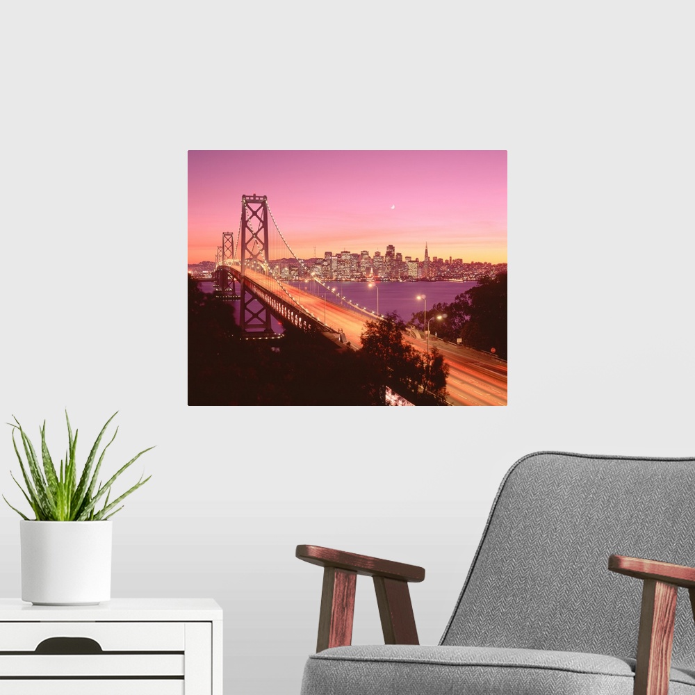 A modern room featuring Big photograph displays a large overpass near the coast of the Western United States brightly shi...