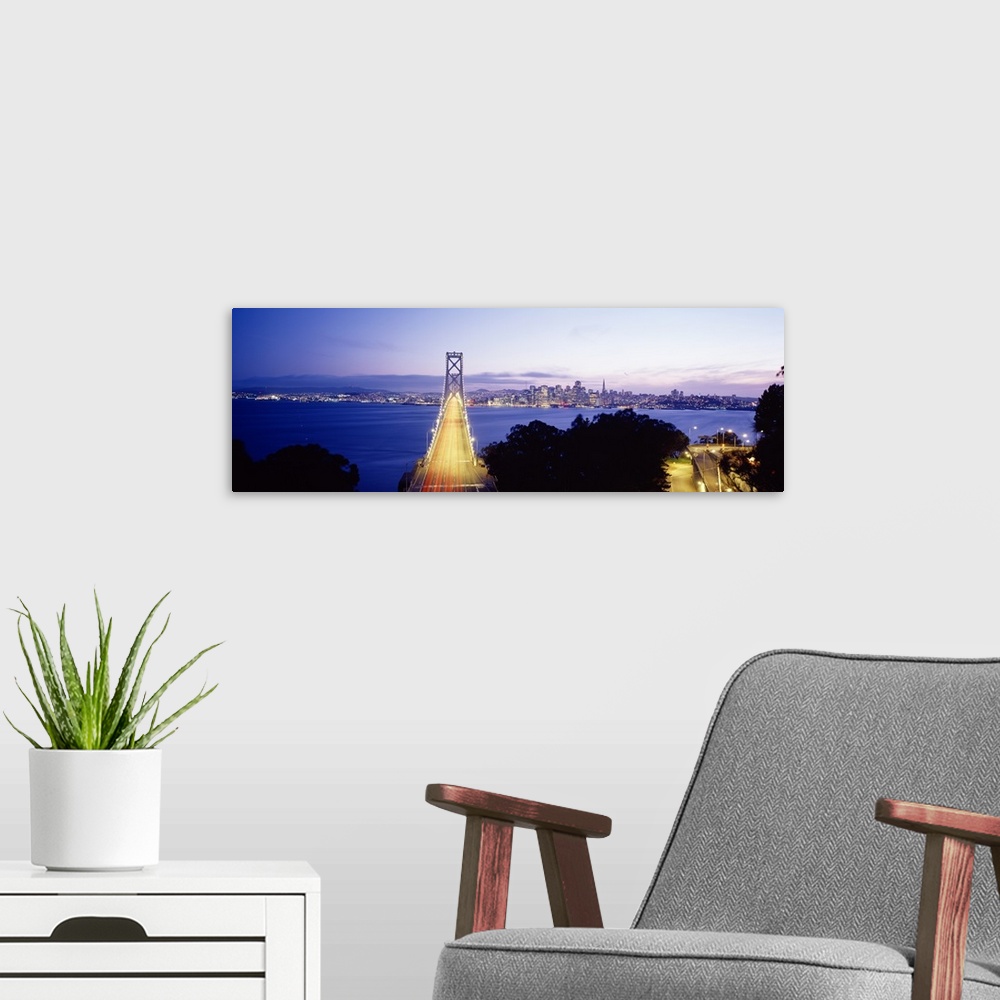 A modern room featuring San Francisco Bridge light up at night over the Bay with views of downtown skyline.