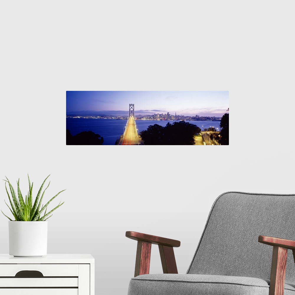 A modern room featuring San Francisco Bridge light up at night over the Bay with views of downtown skyline.