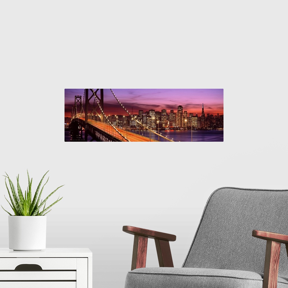 A modern room featuring Panoramic photograph of the San Francisco Bay Bridge and the brightly lit city skyline at dusk.
