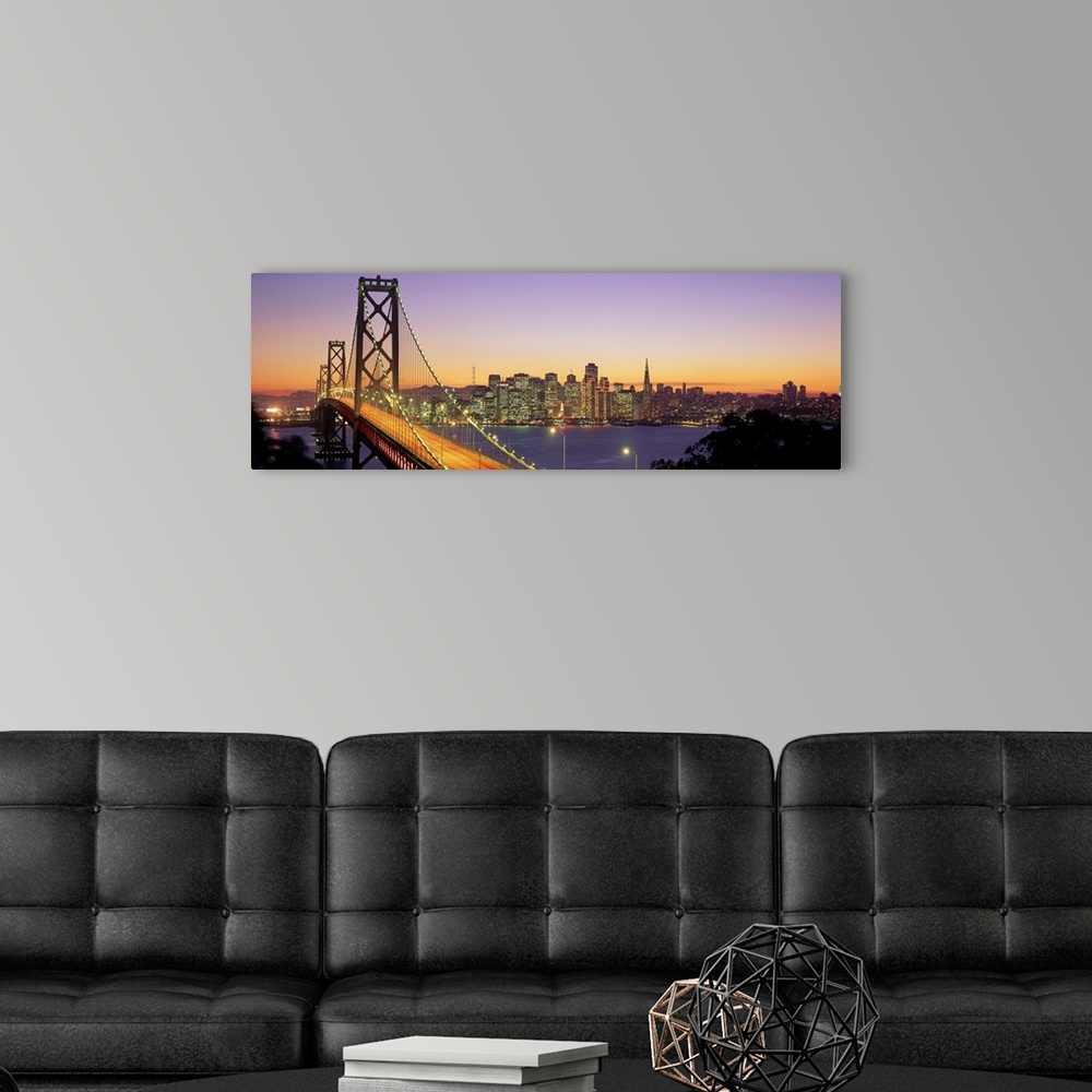 A modern room featuring Twilight and the Golden Gate Bridge with the San Francisco Skyline with a purple and gold sky.