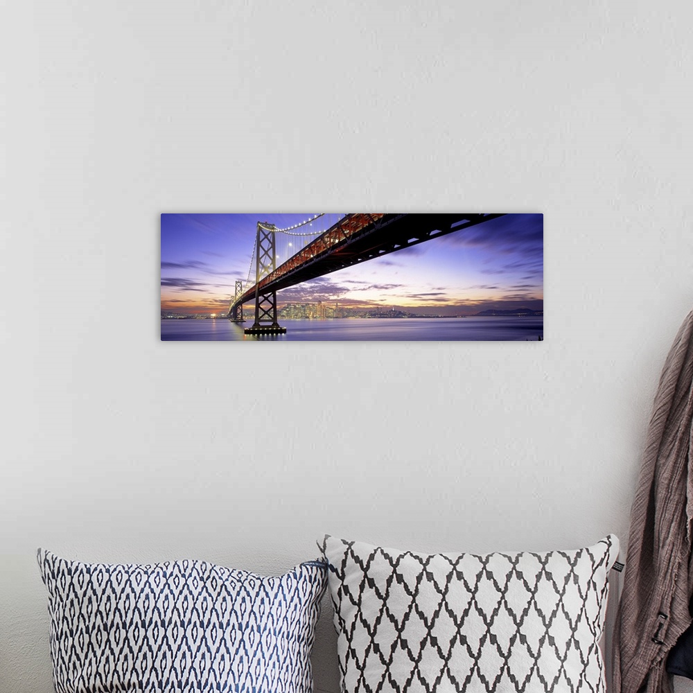 A bohemian room featuring Panoramic photograph of lit up overpass at sunset with city skyline in the distance.