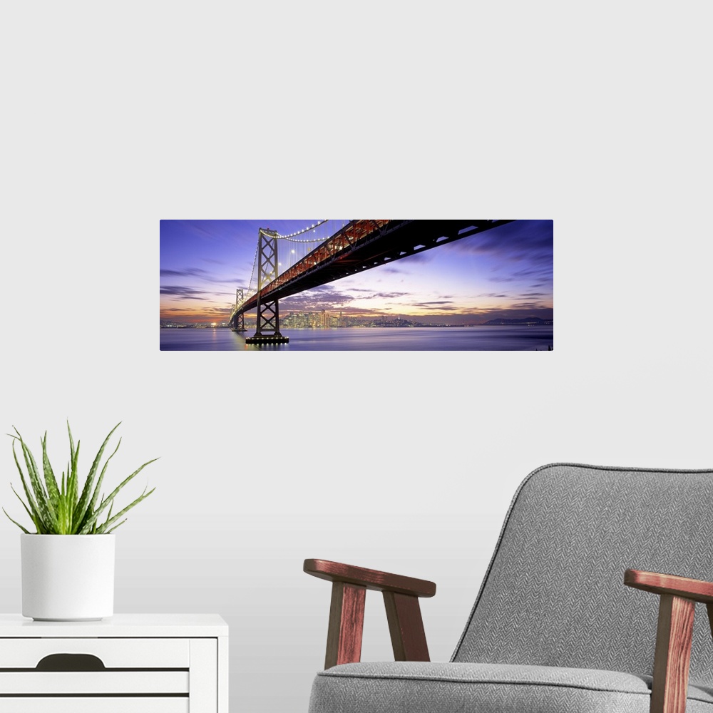 A modern room featuring Panoramic photograph of lit up overpass at sunset with city skyline in the distance.