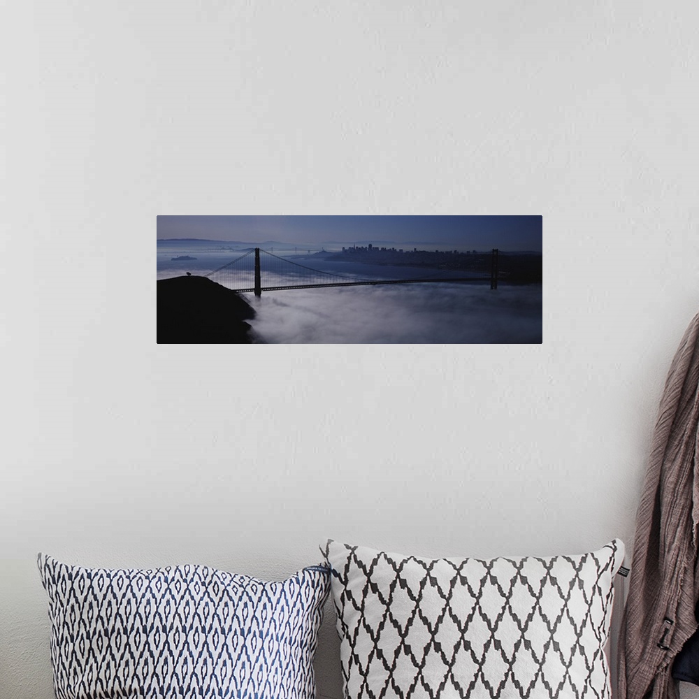 A bohemian room featuring Large panoramic piece of the Golden Gate bridge that has dense fog just under it covering the wat...