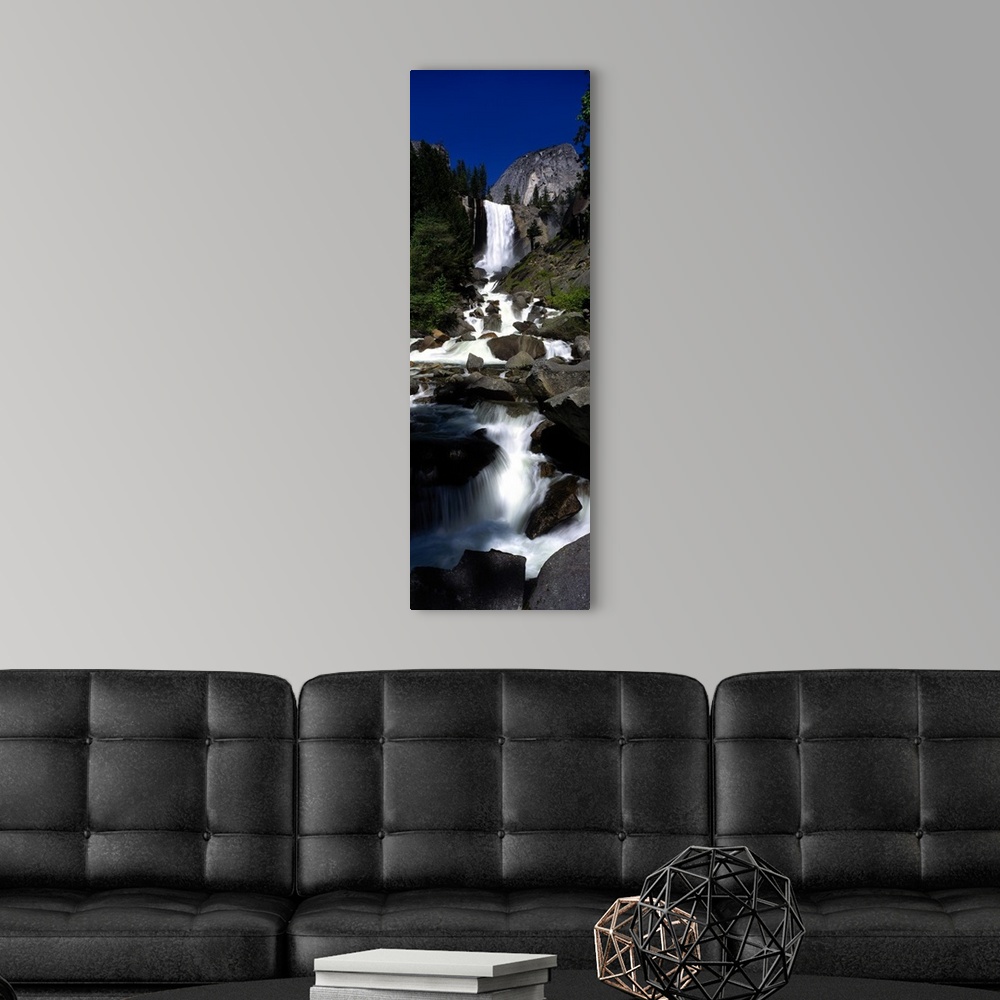 A modern room featuring Vertical panoramic photograph of waterfall flowing into a rocky stream surrounded by trees.