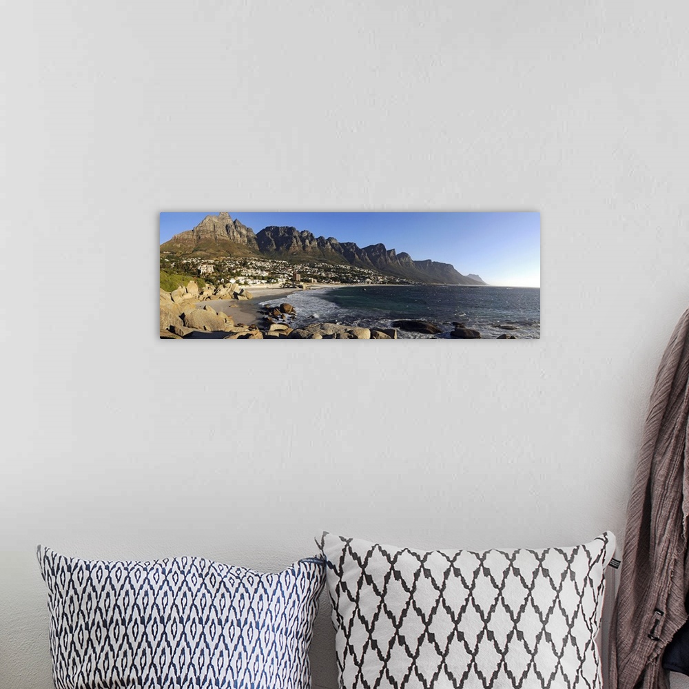 A bohemian room featuring Panoramic photograph of shoreline with rocky cliffs and huge rock formations under a clear sky.
