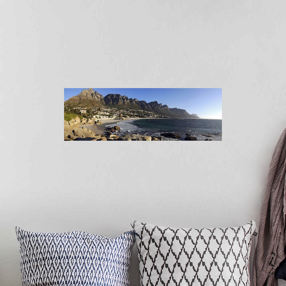 A bohemian room featuring Panoramic photograph of shoreline with rocky cliffs and huge rock formations under a clear sky.