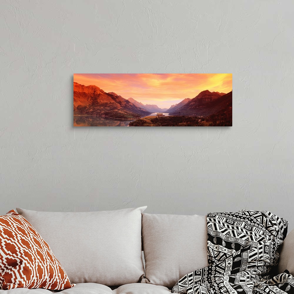 A bohemian room featuring A panoramic photograph of the Canadian wilderness with mountains and trees reflecting in still la...
