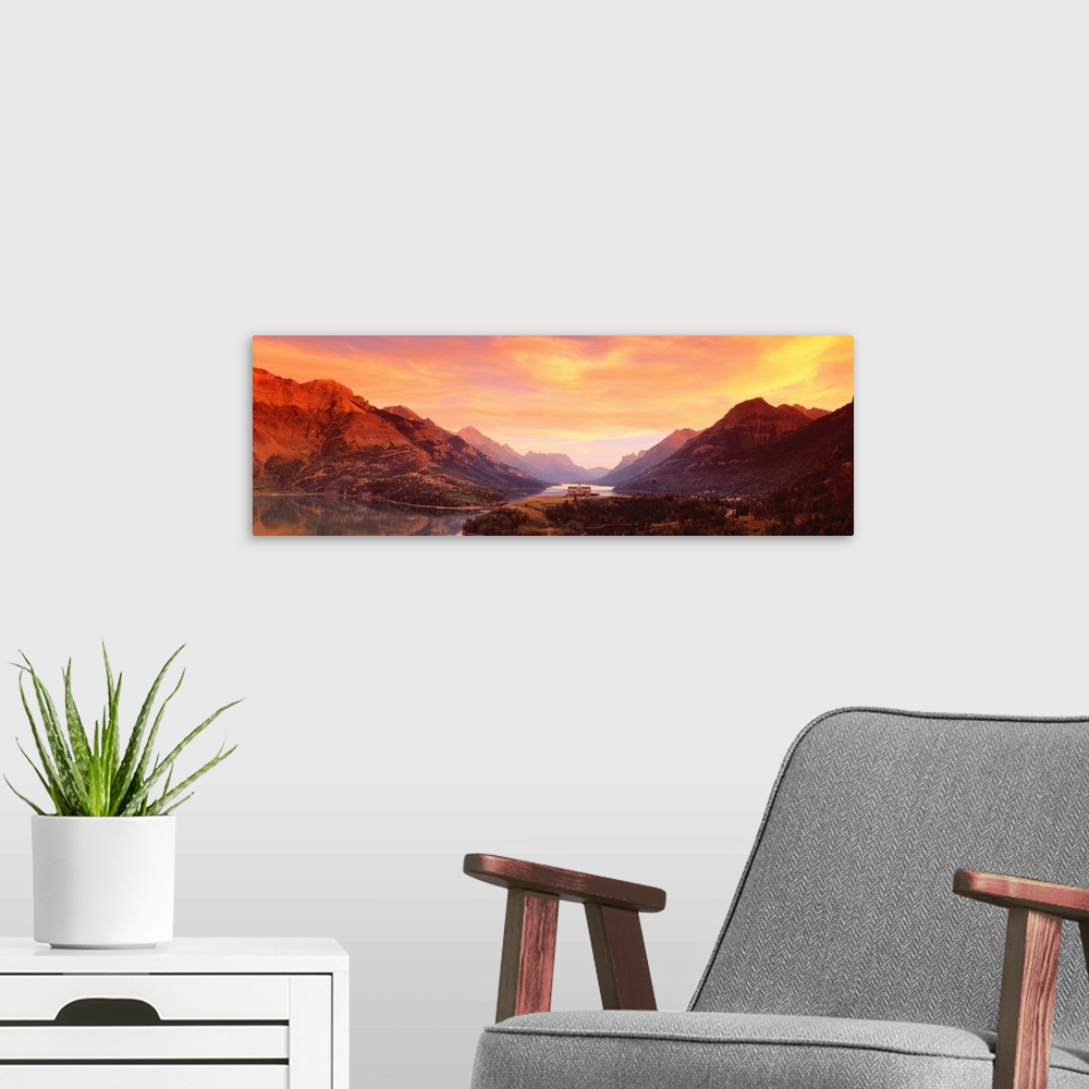 A modern room featuring A panoramic photograph of the Canadian wilderness with mountains and trees reflecting in still la...