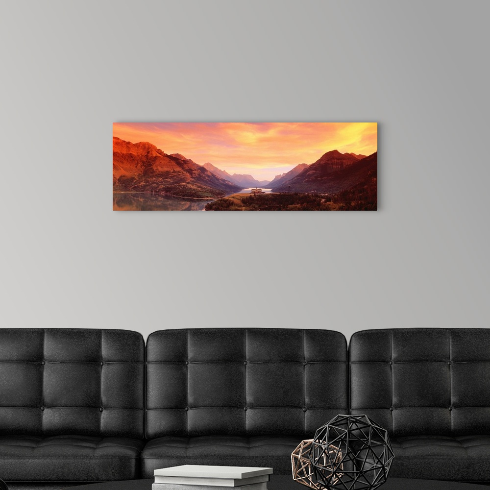 A modern room featuring A panoramic photograph of the Canadian wilderness with mountains and trees reflecting in still la...