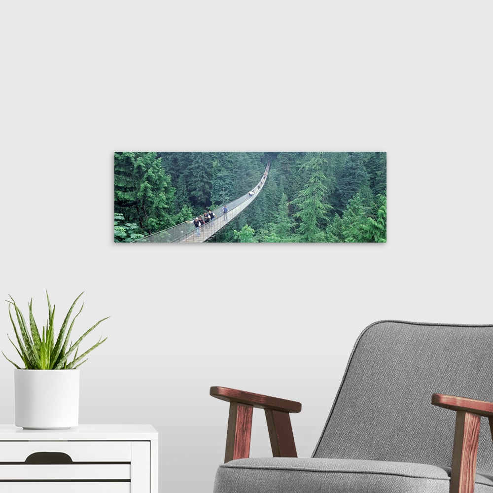 A modern room featuring Long horizontal photo on canvas of people walking across a long bridge that runs through the top ...