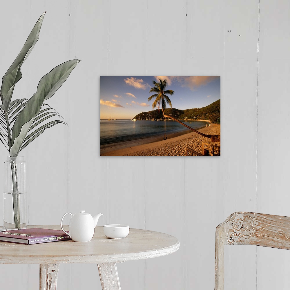 A farmhouse room featuring Photograph of beach front with palm tree that has a tire swing.  There are sailboats in the water...