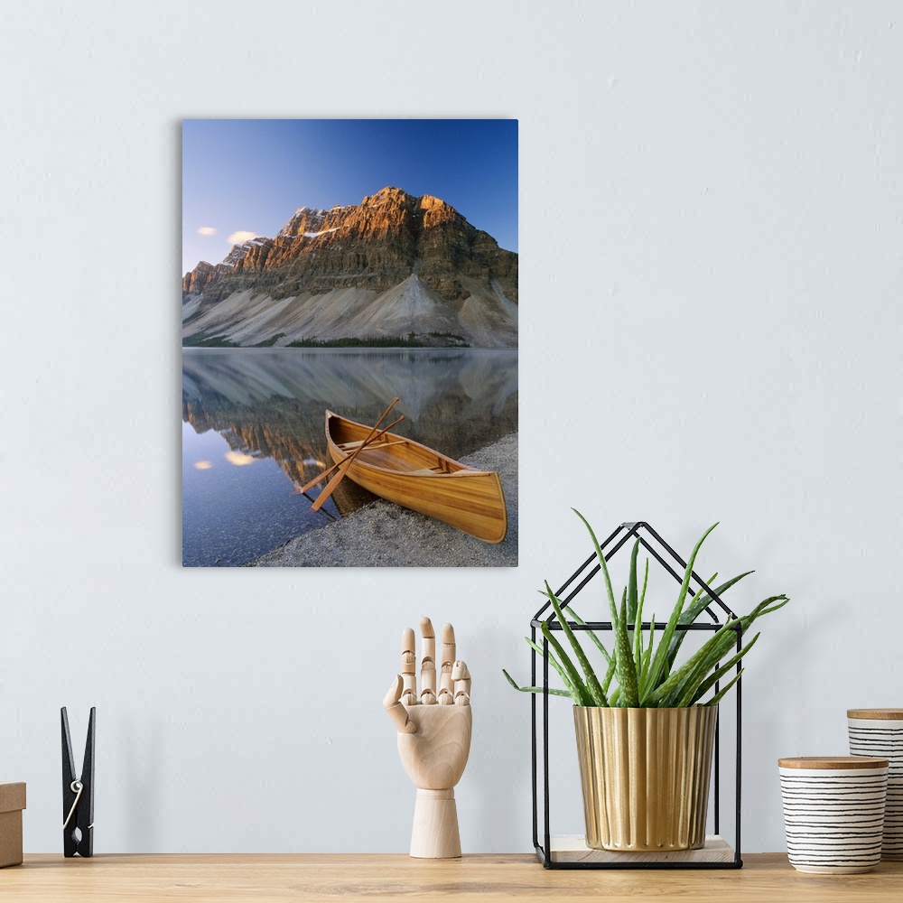 A bohemian room featuring Vertical photograph of a boat on the shore of Bow Lake in Alberta, Canada with a mountain in the ...