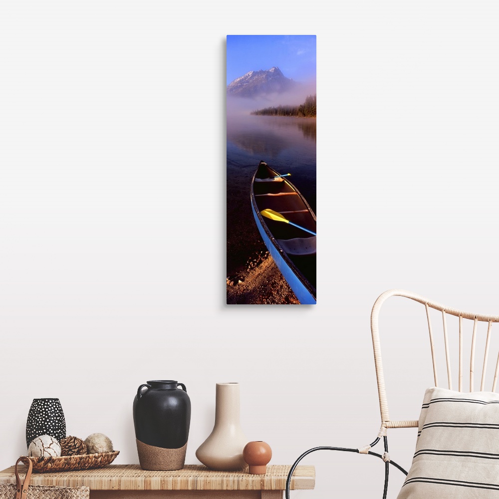 A farmhouse room featuring Tall and narrow canvas photo of a canoe half way in a lake with fog in the distance in front of a...