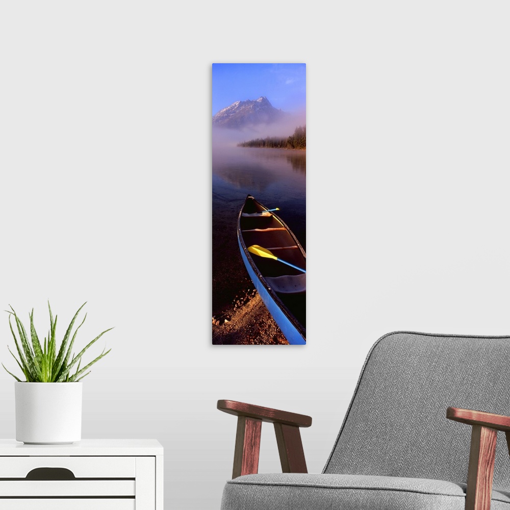 A modern room featuring Tall and narrow canvas photo of a canoe half way in a lake with fog in the distance in front of a...