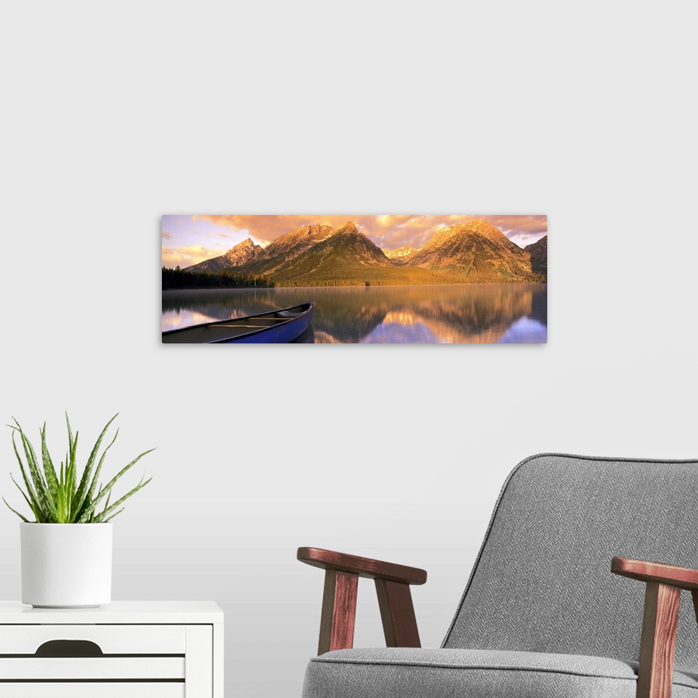 A modern room featuring Panoramic photograph includes a small water vessel as it sits quietly on a large lake in the West...
