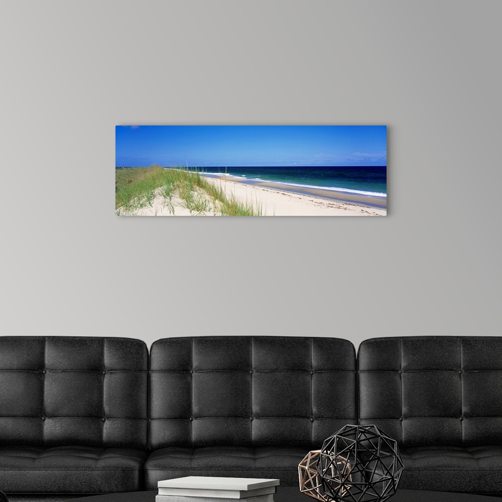 A modern room featuring Panoramic photograph focuses on a long stretch of a sandy beach within North Carolina as the wave...