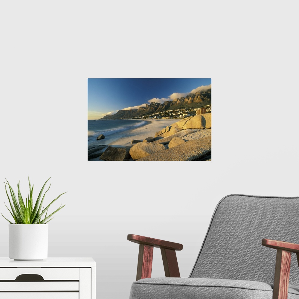 A modern room featuring Horizontal, large photograph of rocks on a beach in front of Cape town, South Africa and mountain...