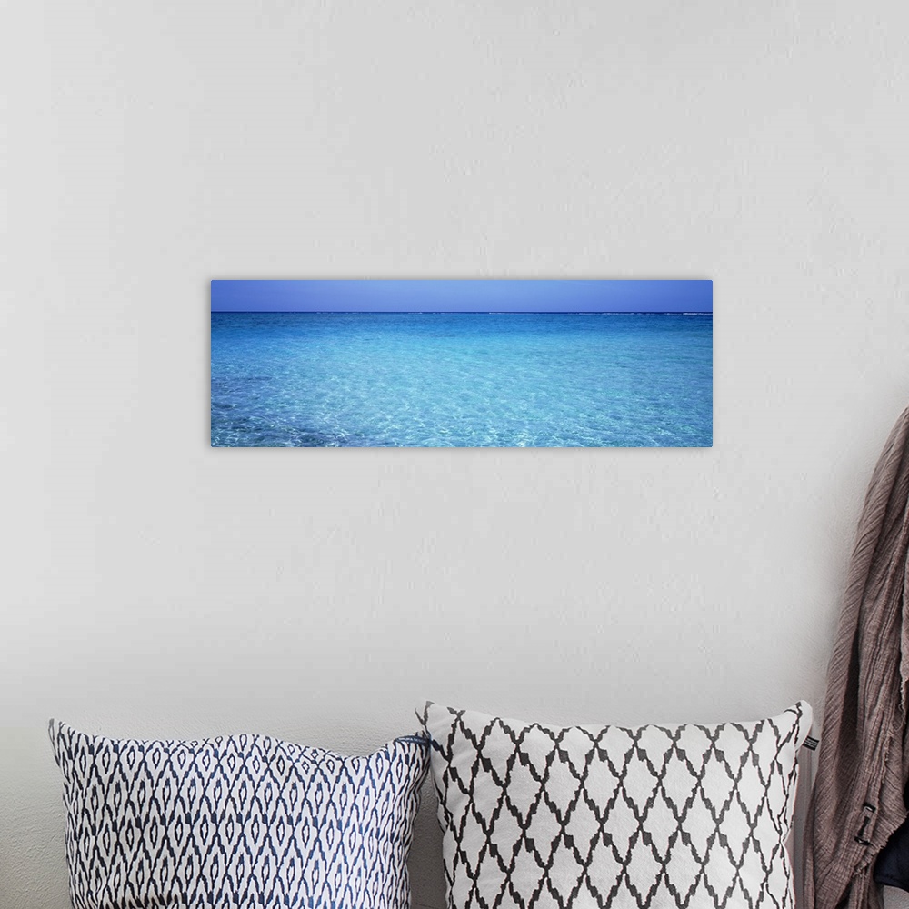 A bohemian room featuring Long panoramic photo print of crystal clear ocean water in the Caribbean.