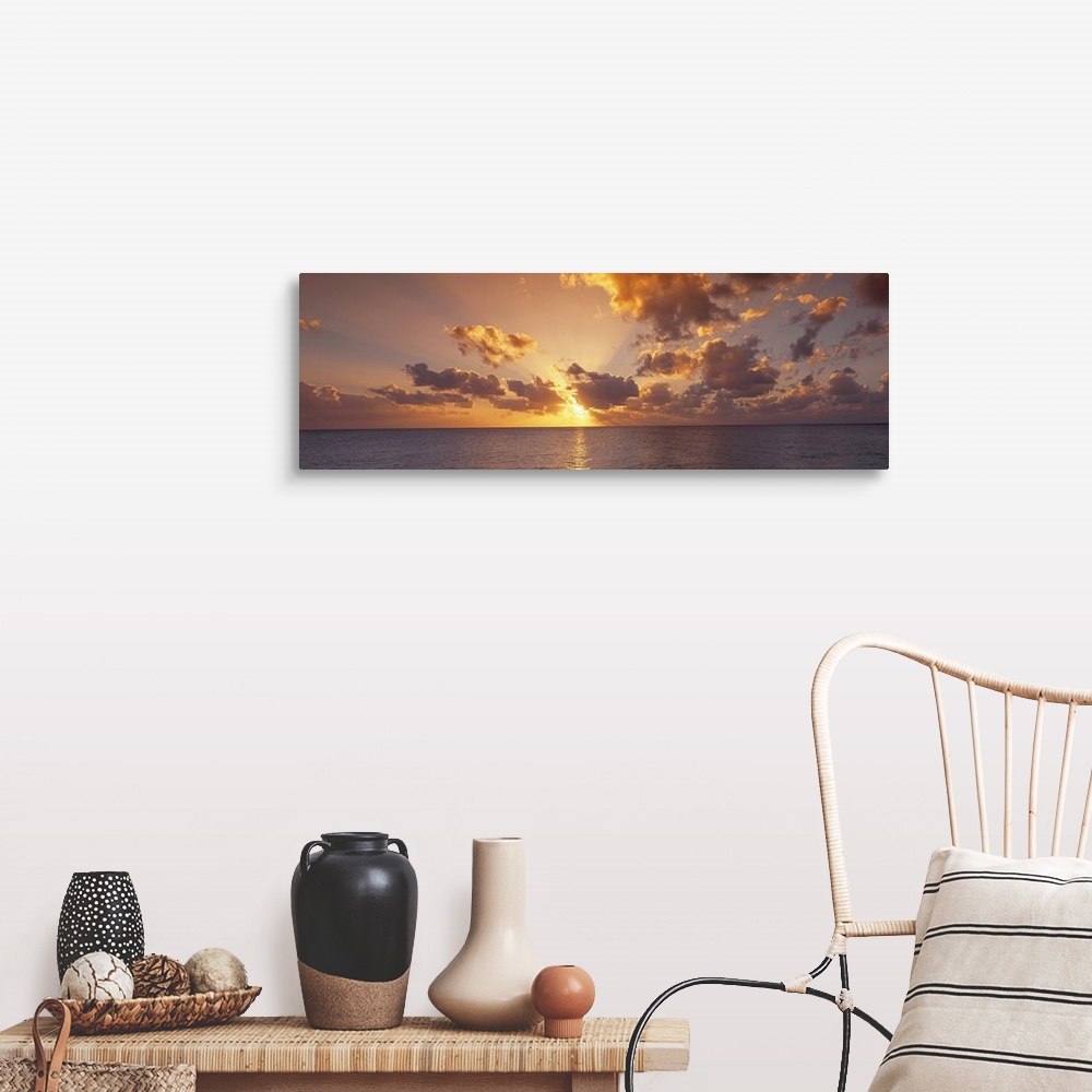 A farmhouse room featuring Wide angle photograph of the setting suns rays beaming through a partly cloudy sky and reflecting...