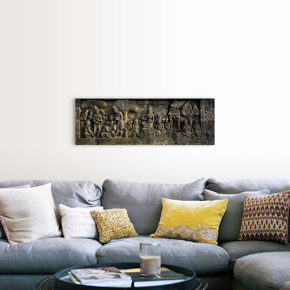 A farmhouse room featuring This elongated piece is of a stone wall that has had artwork carved into it.