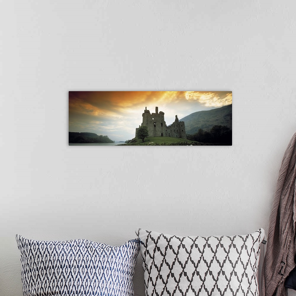 A bohemian room featuring Panoramic photograph of stone palace on hillside at sunset.  There is water in the distance and t...