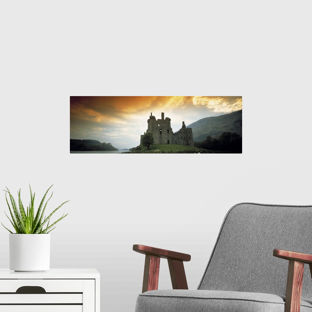 A modern room featuring Panoramic photograph of stone palace on hillside at sunset.  There is water in the distance and t...