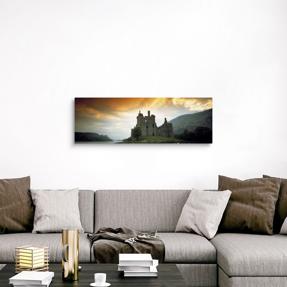 A traditional room featuring Panoramic photograph of stone palace on hillside at sunset.  There is water in the distance and t...