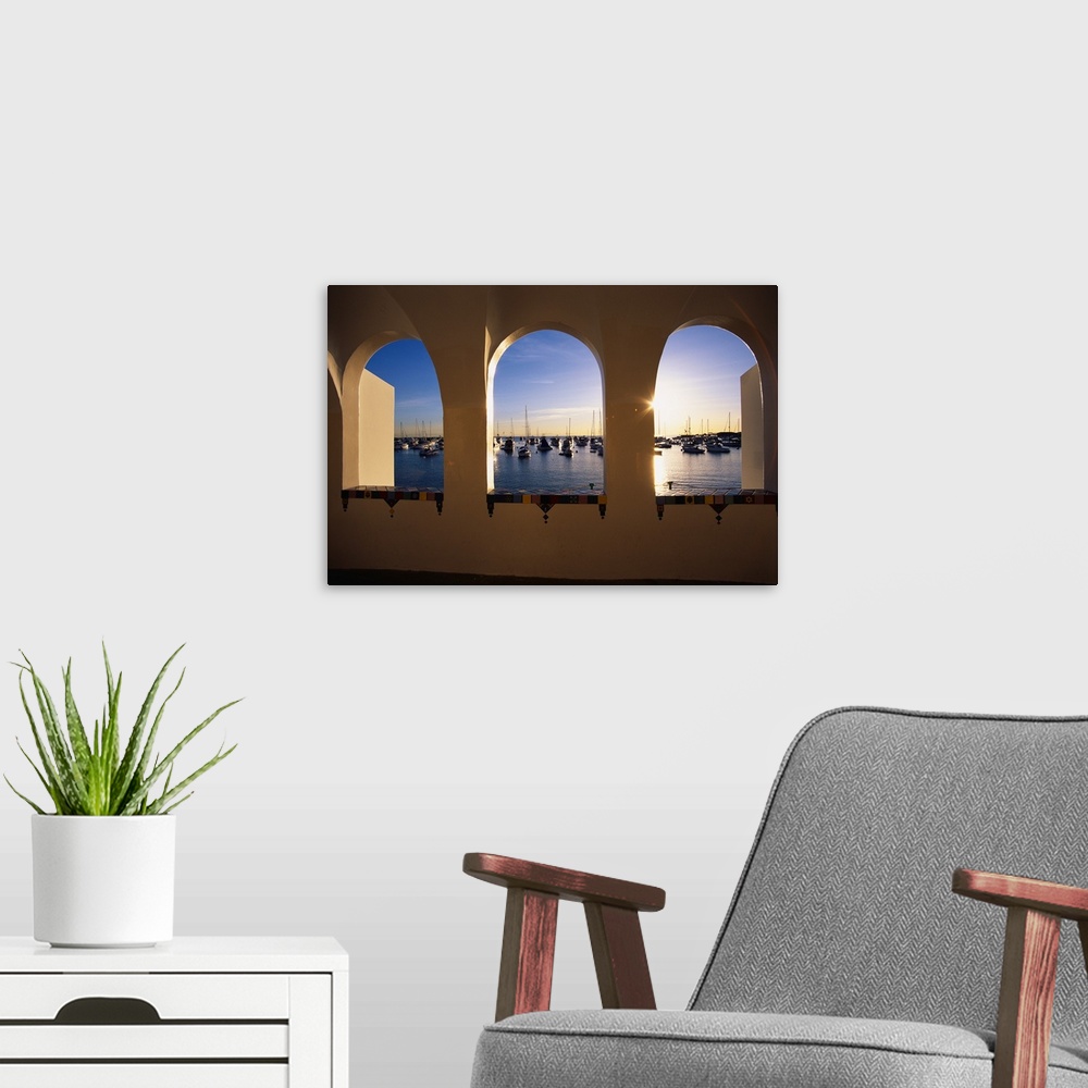 A modern room featuring Big, landscape photograph looking through three windows at the Catalina Casino, numerous boats si...