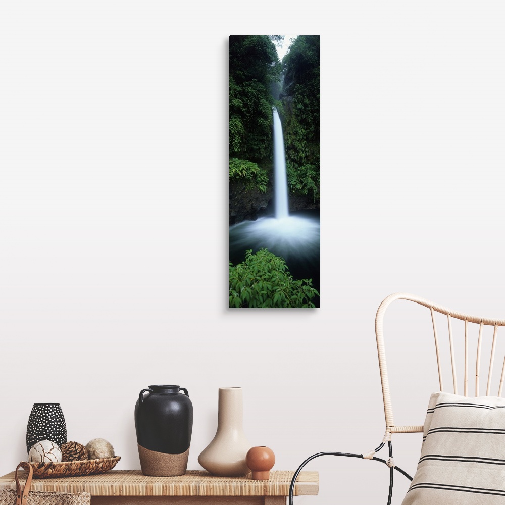 A farmhouse room featuring Vertical canvas print of a narrow but powerful waterfall rushing down from a tropical forest.