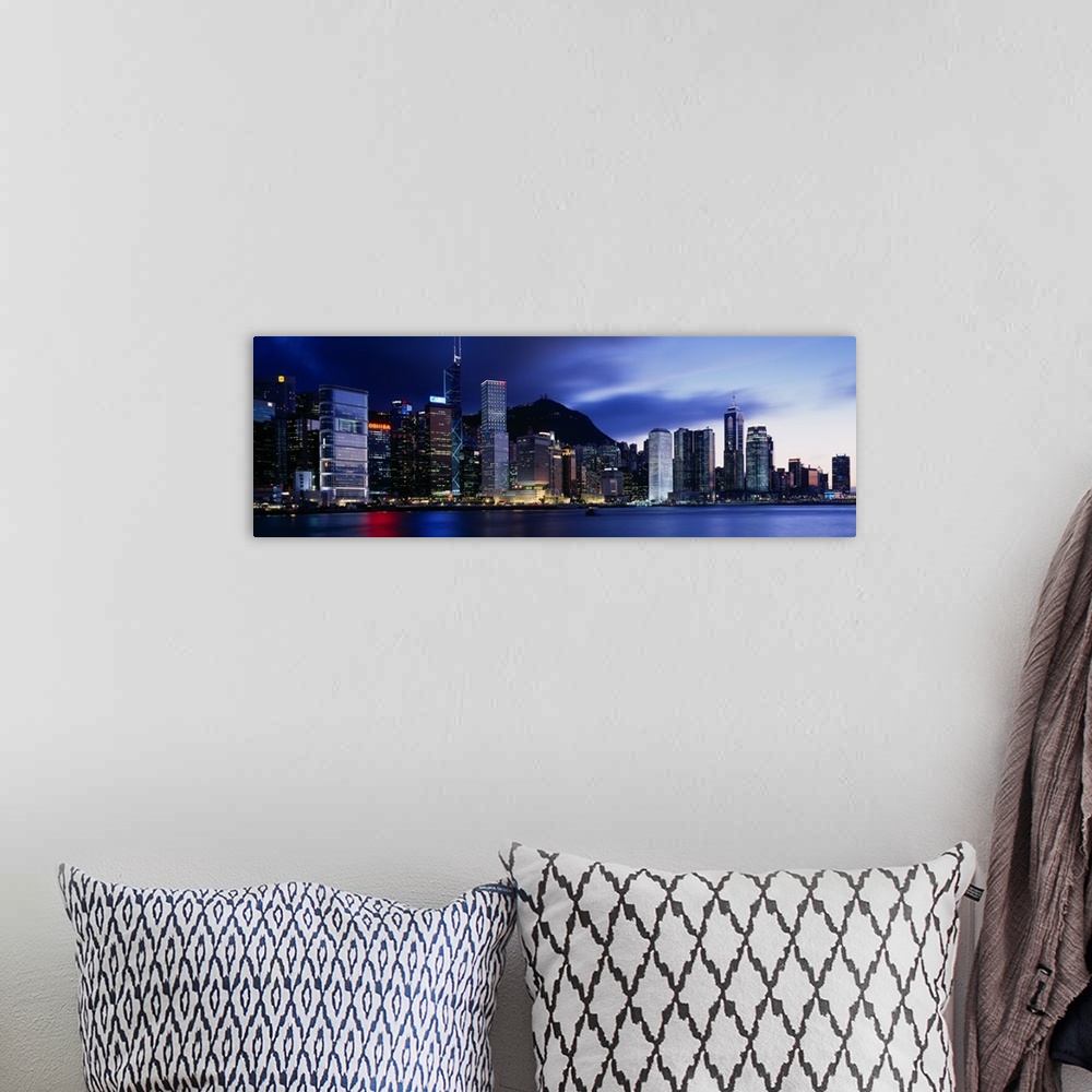 A bohemian room featuring Panoramic photograph displays the bright skyline of a famous city reflecting over a portion of Vi...