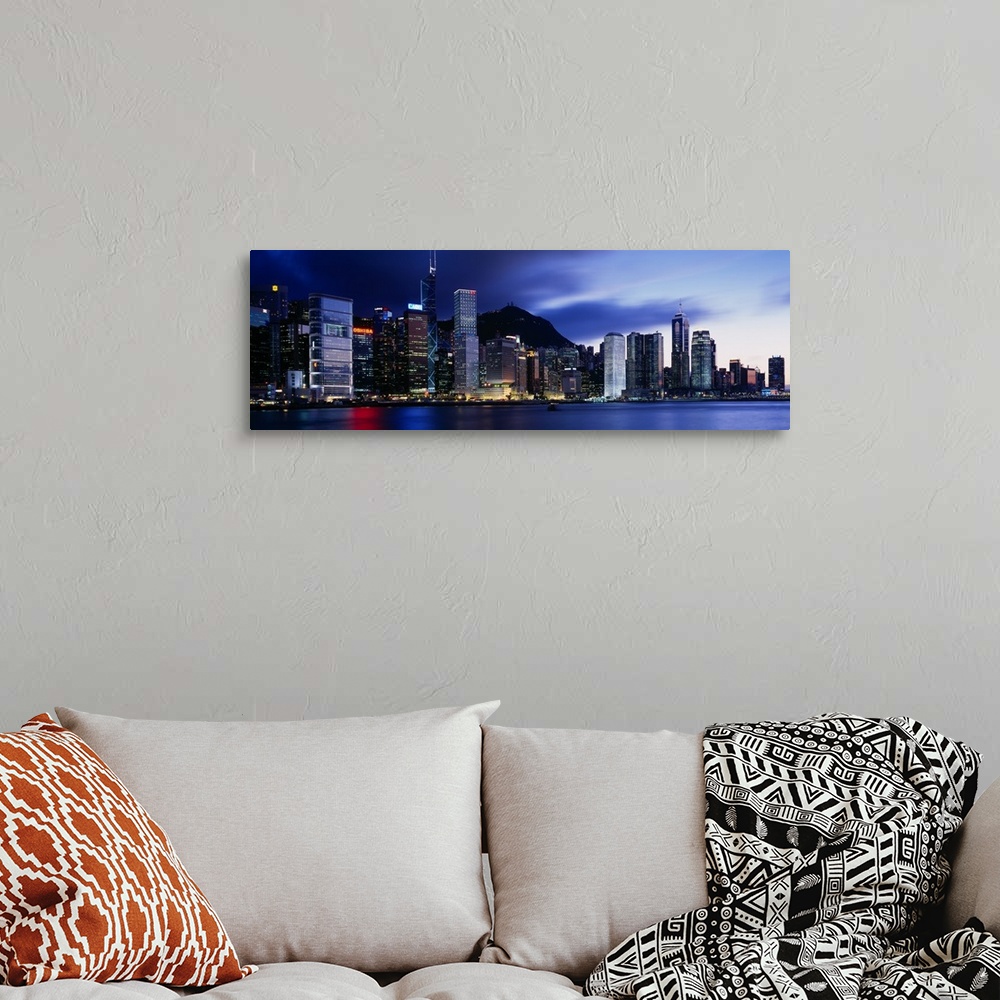 A bohemian room featuring Panoramic photograph displays the bright skyline of a famous city reflecting over a portion of Vi...