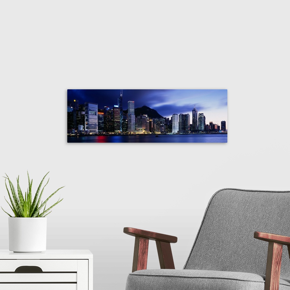 A modern room featuring Panoramic photograph displays the bright skyline of a famous city reflecting over a portion of Vi...