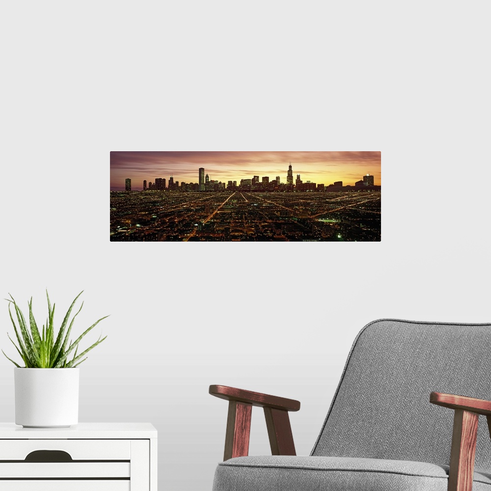 A modern room featuring Panoramic photograph of skyline and city lit up at sunset.