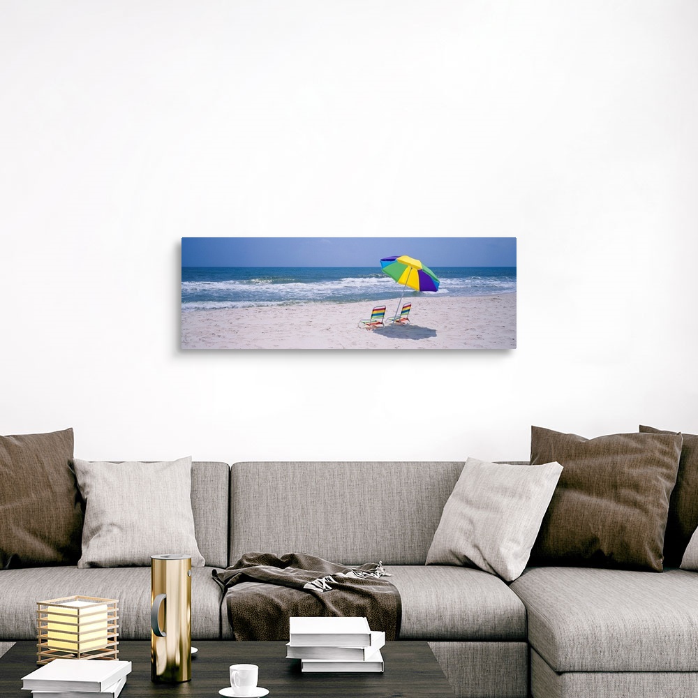 A traditional room featuring Panoramic photograph includes two chairs sitting under a vibrantly colored umbrella as the waves ...