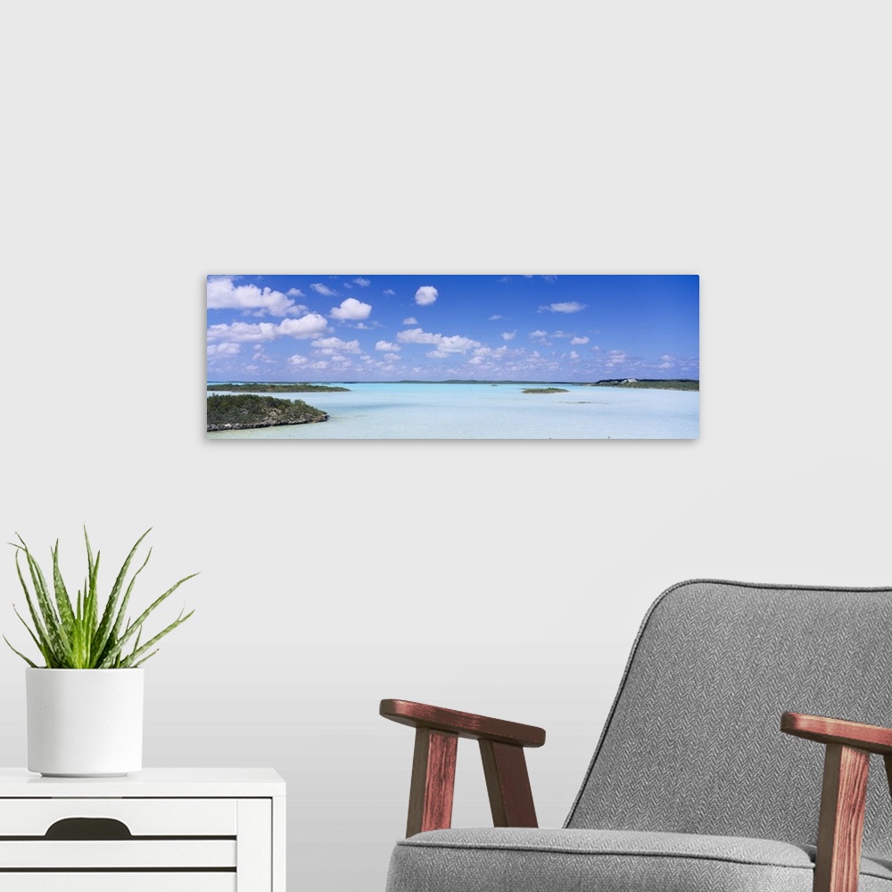 A modern room featuring Panoramic photograph of inlet with grass covered sand bars under cloudy skies.