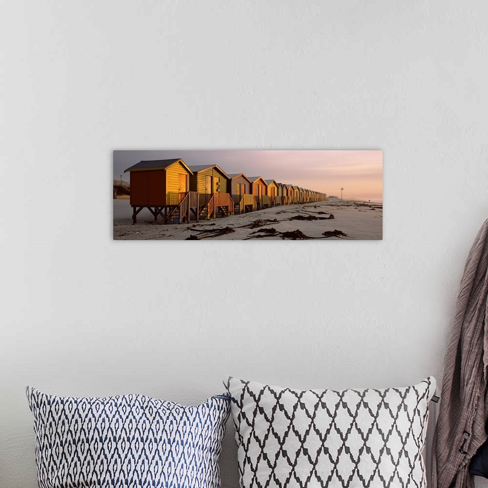 A bohemian room featuring A panoramic photograph of a row of buildings built on the sandy shoreline glowing in the light of...