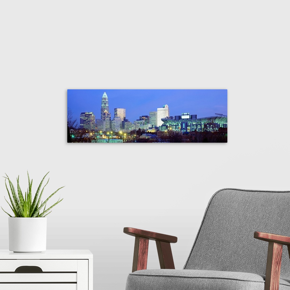 A modern room featuring Panoramic cityscape photograph of the Queen City downtown at twilight.