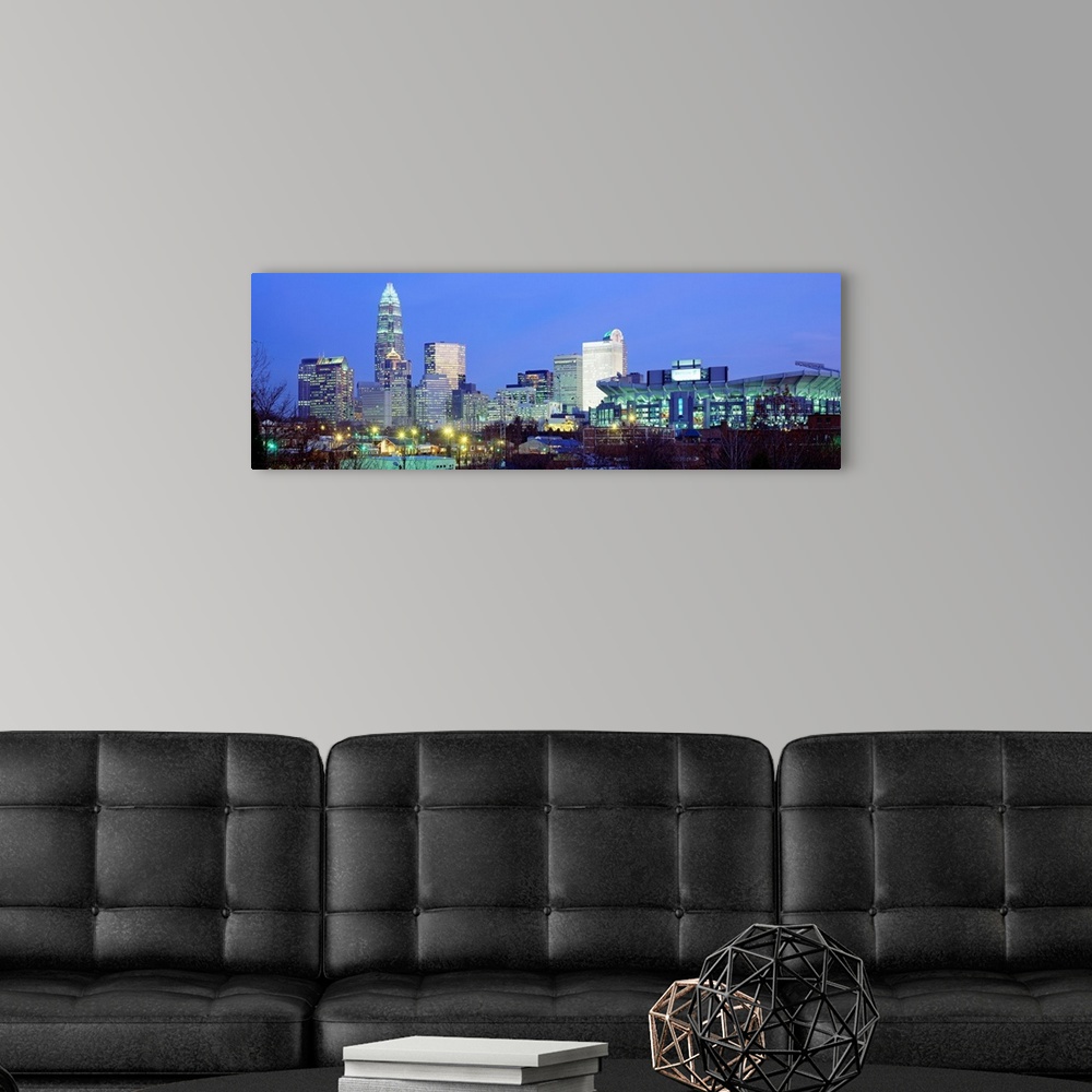 A modern room featuring Panoramic cityscape photograph of the Queen City downtown at twilight.