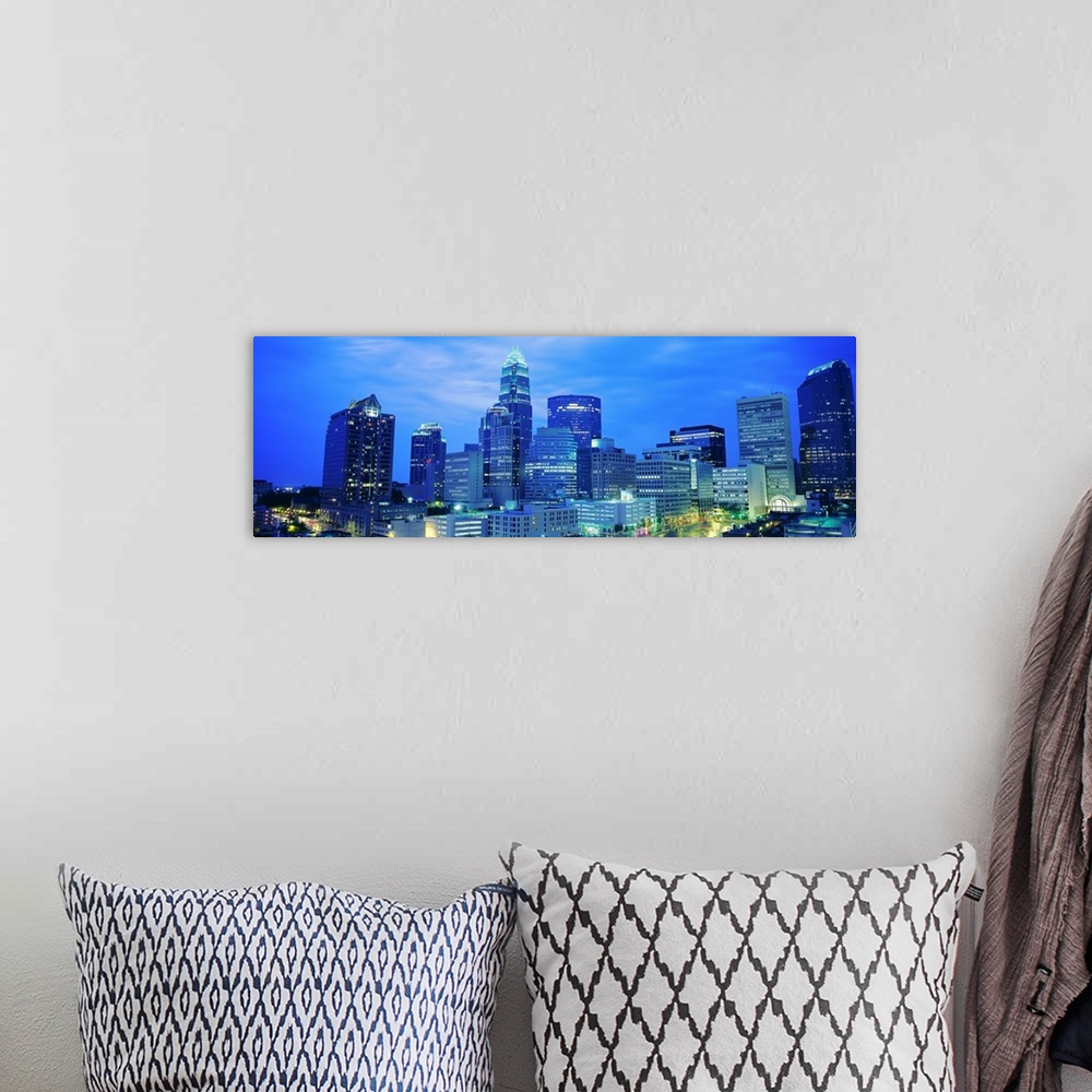 A bohemian room featuring Giant, panoramic photograph of the Charlotte skyline at night.