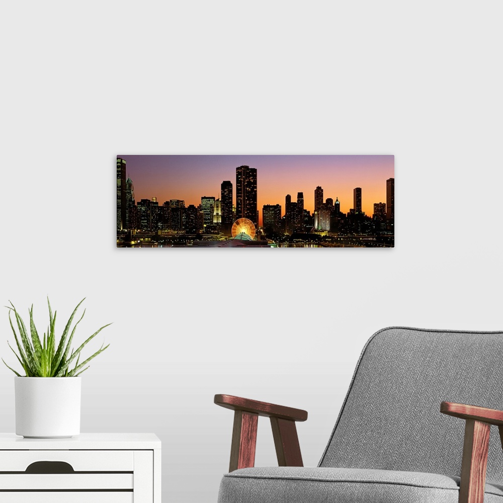 A modern room featuring The skyscrapers in Chicago have been silhouetted by the sunset but the windows are illuminated.