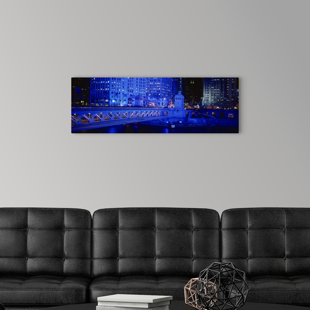 A modern room featuring Panoramic view of the Michigan Avenue Bridge during the night. The buildings in the background an...