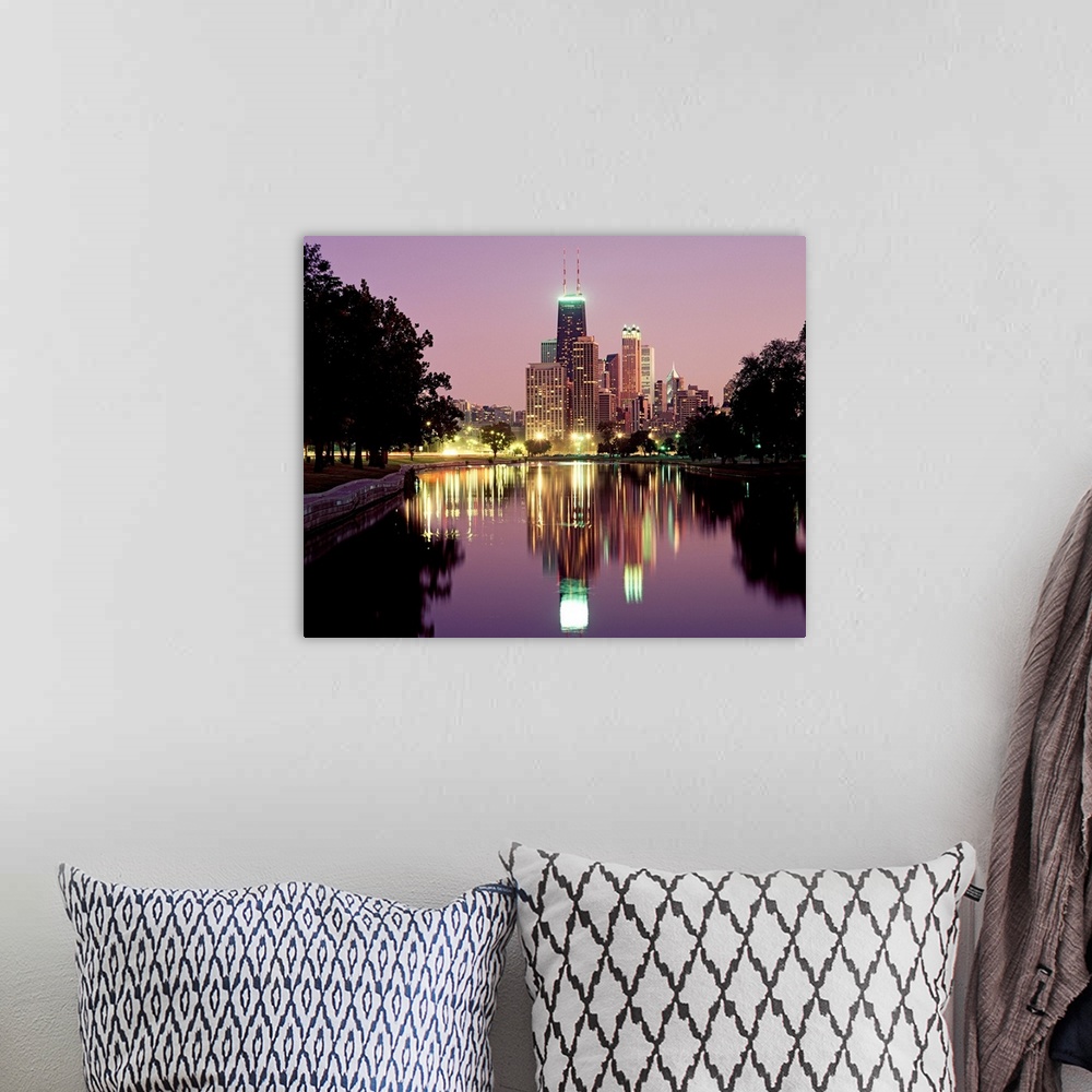 A bohemian room featuring Oversized photograph wall art of city lights and skyscrapers reflecting in a pond in a park.