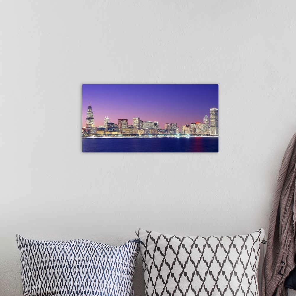 A bohemian room featuring Large photo on canvas of a lit up cityscape by the waterfront at dusk.