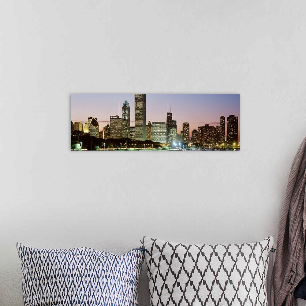 A bohemian room featuring Panoramic print of a cityscape illuminated at dusk along a waterfront.