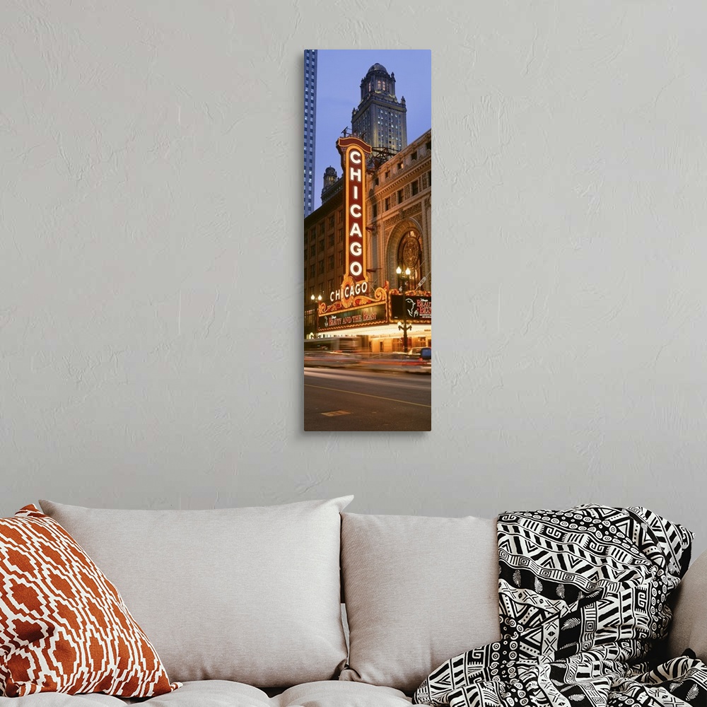 A bohemian room featuring Vertical panoramic photograph of downtown theater with lit up marquee.  There is a skyscraper in ...